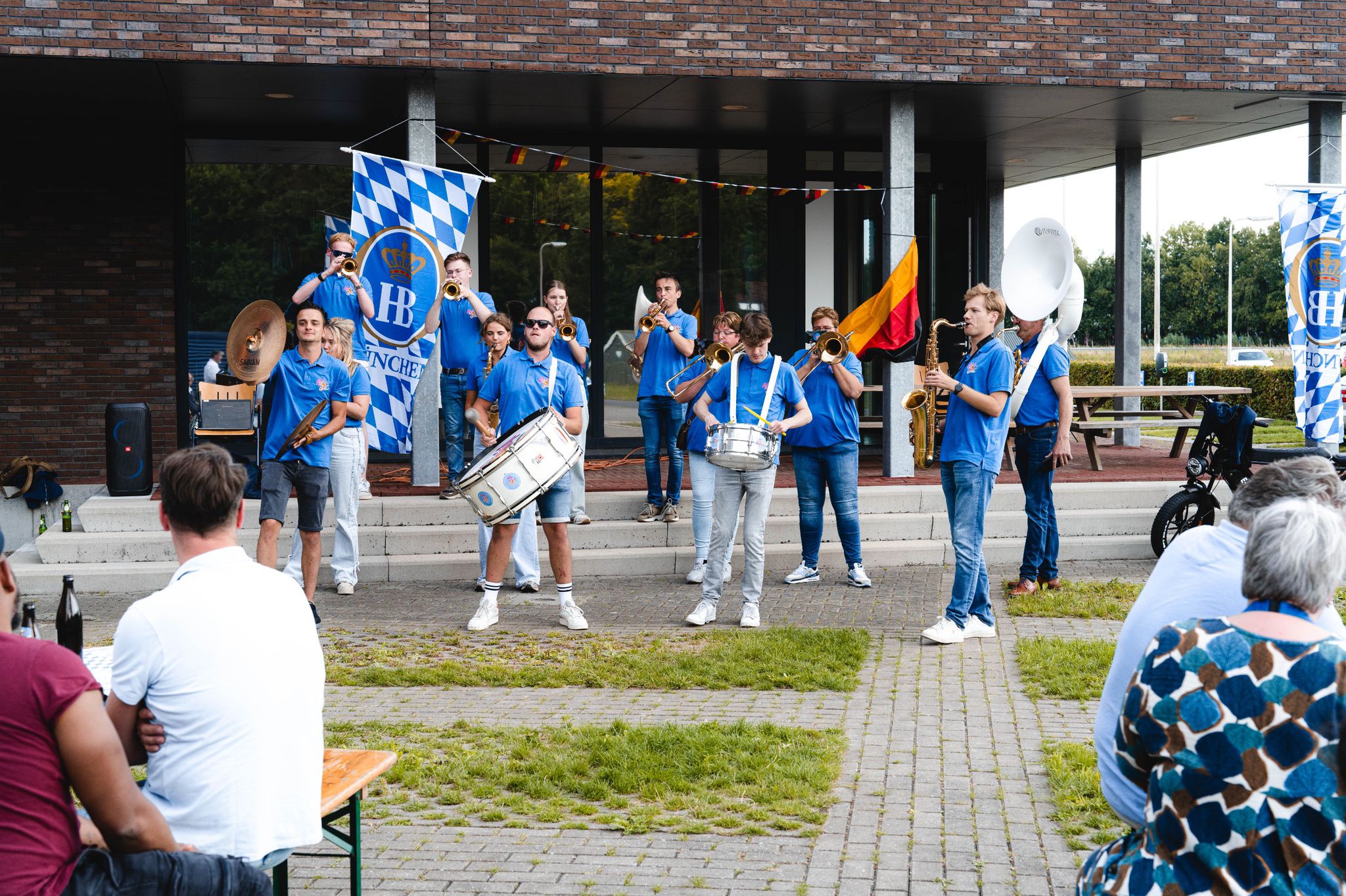 Gezelligheid en publiek bij een optreden van de blaaskapel